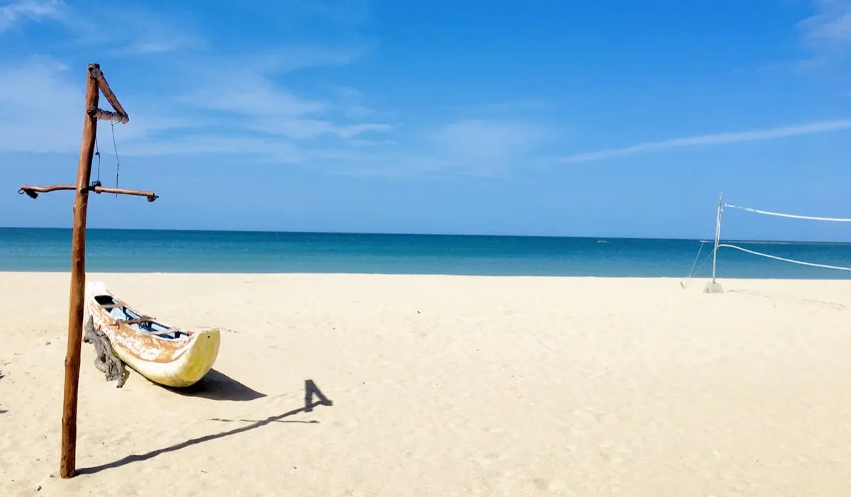 A fishing boat on the white sand at Pasikudah beach